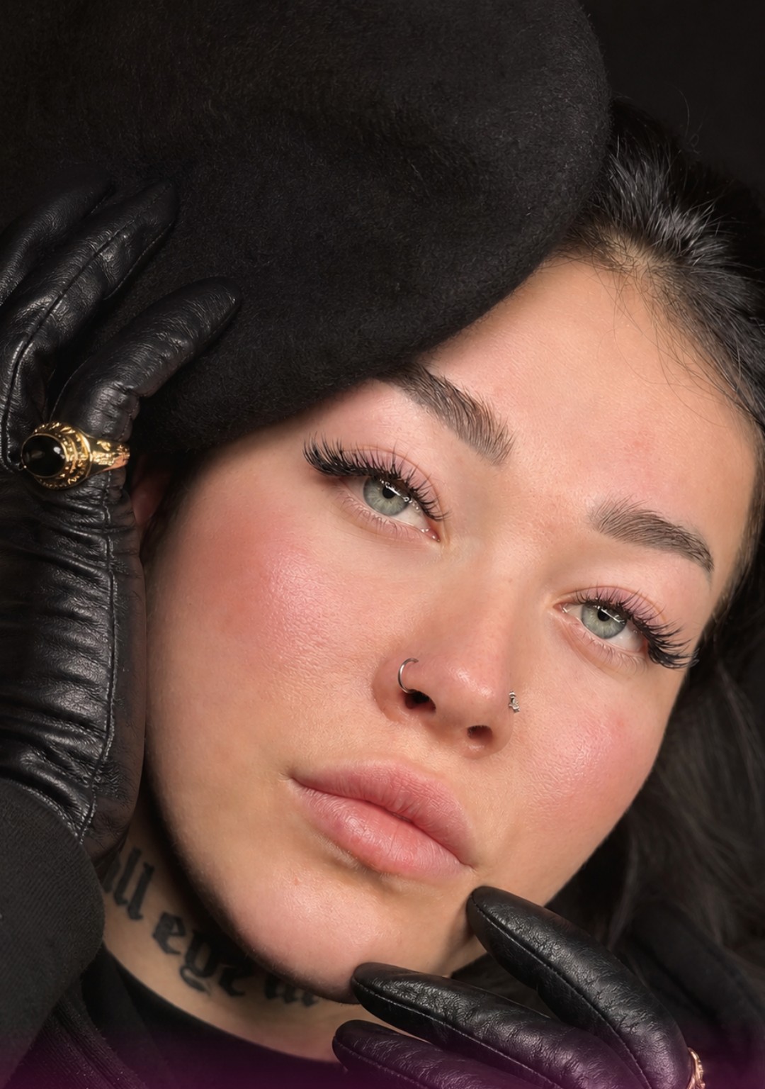 Model met zwarte baret en leren handschoenen, verzorgde wenkbrauwen en lichte wimpers